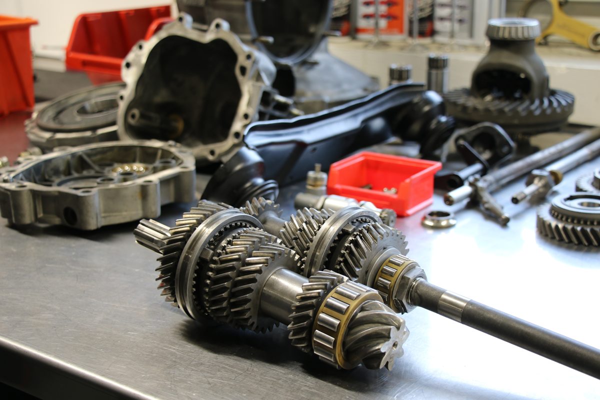 Zerlegtes Porsche 901 Getriebe mit Wellen und Gehäuseteilen auf der Werkbank