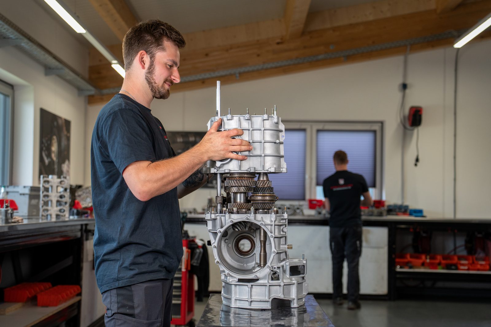 Mechaniker setzt das Gehäuse eines Porsche Schaltgetriebes auf den Radsatz