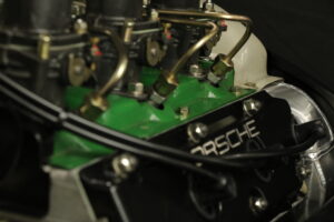 Motorrevision Porsche 911 2.2l E Der Porschemotor 911 2.2l E wurde komplett überarbeitet. Das Hauptlagergasse wurde auf Übermaß gespindelt und komplett neu gelagert. Zylinderköpfe wurden geplant, Glasperlen gestrahlt, die Ventilführungen erneuert und die Ventilsitze nachgeschnitten. Auch die Ventilfedern wurden neu eingemessen und der Motor bekam neue Kolben und Zylinder des Porsche 911 2.4 S Mahle. Die Einzeldrosselklappenanlage haben wir neu justiert. Neu eingestellt und geprüft wurde die Einspritzpumpe und im Anschluss der Motor mit dem Auto abgestimmt. Zahnräder der Nockenwelle und Zwischenwelle haben wir durch neue ersetzt. Nachdem die Lichtmaschine überholt wurde bekam der 911er noch eine neue Ölpumpe und Ölkühler. Standardgemäß werden bei einer Motorrevision Porsche 911 alle Schrauben und Gestänge Gold galvanisiert und das Lüfterrad neu gelagert und in Wunschfarbe lackiert. Der Motor läuft wieder rund und das tolle Fahrerlebnis mit dem 911er kann wieder los gehen.