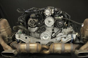 Bei diesem Porsche 996 mit 3.4l wurde bei zwei Zylindern ein Kolbenfresser festgestellt und somit wurden zwei neue Kolben eingesetzt. Grundsätzlich werden bei uns alle sechs Stahlbuchsen neu gesetzt. Die Zylinderköpfe wurden geplant und instandgesetzt mittels Sandstrahlen und Polieren der Ventile. Gleitschienen und Kettenspanner wurden getauscht, die Steuerketten erneuert und sämtliche Dichtungen durch neue ersetzt. Für einen noch besseren Sound des Motors wurde eine originale Klappenauspuffanlage von Porsche verbaut. Nach der abschließenden Probefahrt sind wir sehr zufrieden mit dem Ergebnis und können das Auto wieder seinem Besitzer übergeben.