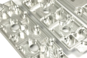 Ventildeckel Porsche 964 Wie auch die Ventildeckel Porsche 964 produzieren, entwickeln und konstruieren wir inzwischen unsere eignene Ersatzteile. Durch unsere CNC-Fertigung und unserer CAD-Konstruktion sind wir in der Lage Ersatzteile neu zu entwickeln. Die Ventildeckel auf den Fotos wurden für den Porsche 964 entwickelt. Diese wurden als verstärkte Version für den Straßen und Rennsport konstruiert, und können mit dem Original Dichtungssatz verbaut werden. Sie ersetzten die gegossenen originalen Ventildeckel des Porsche 964 und können durch Ihren Aufbau, Material und hochpräzise Fertigung, Passgenauigkeit und Langlebigkeit garantieren. Die Ventildeckel für den Porsche 964 werden aus dem vollen Aluminiumblock gefräst. Durch die verstärkten Kühlrippen wird zusätzlich Wärme abgeleitet und die Öltemperatur bleibt konstant niedrig. Desweitern werden die Ventildeckel für Porsche 964 harteloxiert in natur oder schwarz, dies schützt vor Korrosion und trägt nicht auf das Material auf.