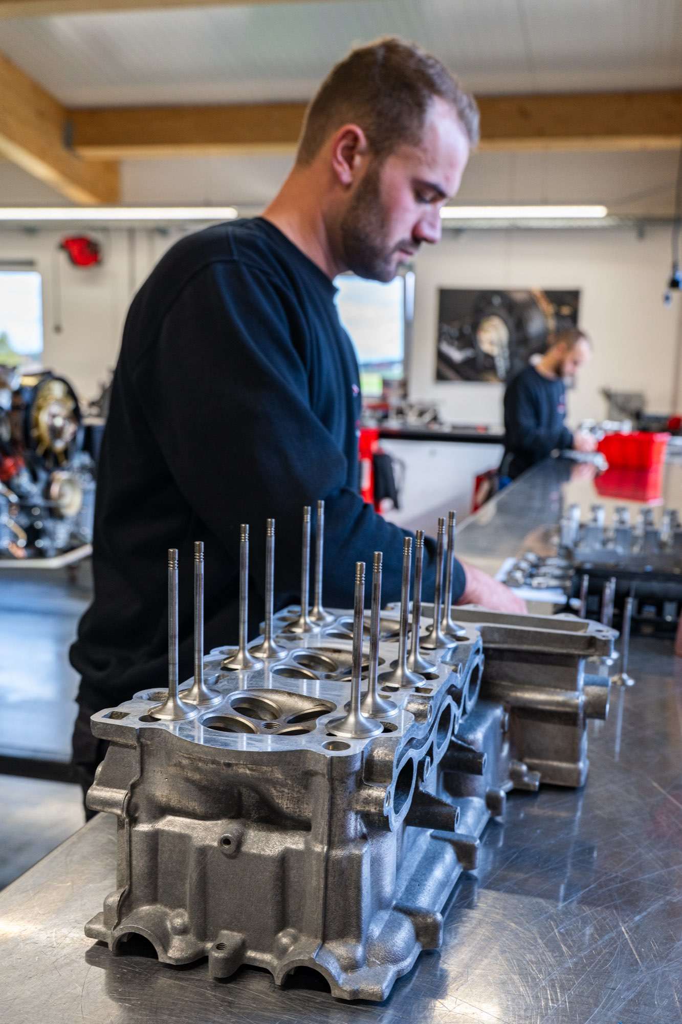 Porsche Zylinderkopf mit eingesetzten Ventilen auf der Werkbank, Mechaniker der Motorenmanufaktur Paintmayer bei der Überarbeitung der Zylinderköpfe